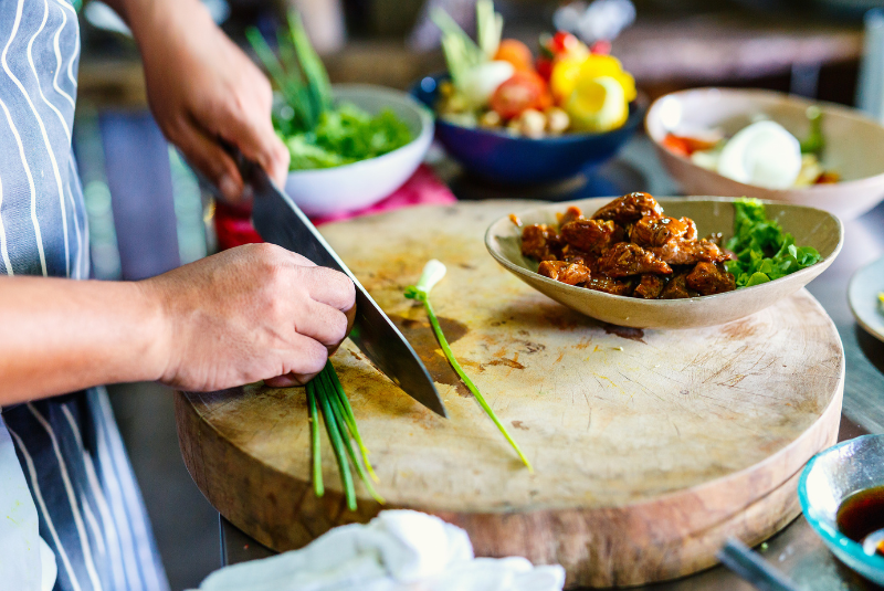 Personne qui coupe prépare un plat dans un cours de cuisine en thailande