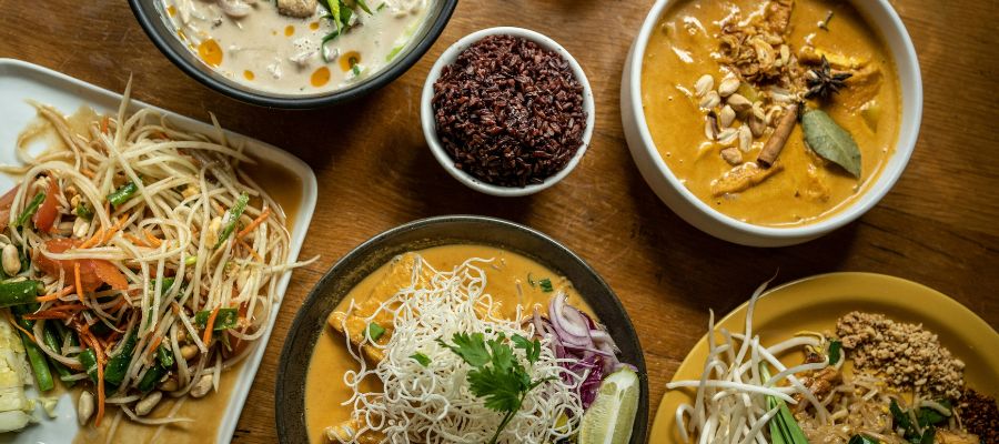 Plats typiques thaïs, dont un khao soi et une salade de papaye épicée